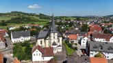 Blick von oben auf Großenlüder mit der Kirche im Vordergrund und das Rathaus im Hintergrund