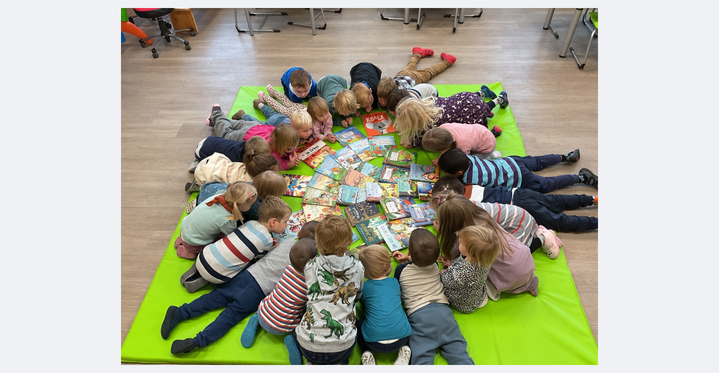 Kinder der Kita Zwergenland sitzen im Kreis mit neuen Bücher