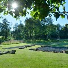 ein Blick in den historischen Naturpark Sodegarten Großenlüder mit einer großen Grünfläche und Resten der historischen Ausgrabungen - Link öffnet seitenüberlagerndes Dialog-Fenster