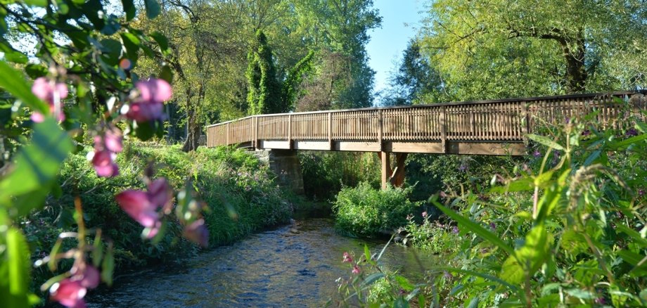 Historischer Naturpark Sodegarten Großenlüder die Fußgängerbrücke über die Lüder zum Sodegarten